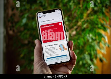 Eine Hand hält ein smartphone mit einer Infektionswarnung im Corona-App Display Banque D'Images