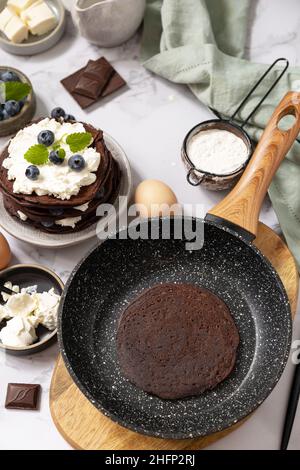 Petit déjeuner sain.Ingrédients pour la cuisson et crêpes délicieuses avec myrtilles et ricotta sur un plan d'examen en marbre. Banque D'Images