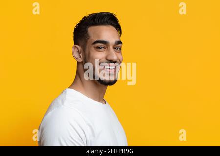 Portrait du beau jeune homme du Moyen-Orient sur jaune Banque D'Images