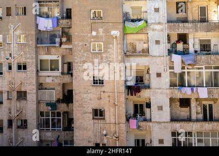 Cartagena, Espagne - 29 décembre 2021 : vue frontale d'un ancien immeuble d'appartements avec buanderie suspendue par les fenêtres Banque D'Images