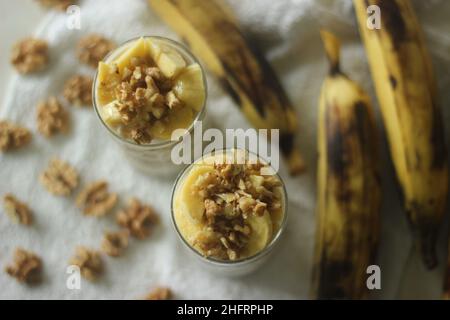 Avoine de nuit avec plantain mûr et noix.Fait en trempant des flocons d'avoine et des graines de chia dans du lait servi avec des tranches de plantains, des noix et sucré Banque D'Images