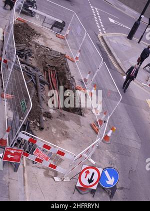 vue aérienne des travaux routiers, trou dans la route avec barrières, câbles posés Banque D'Images