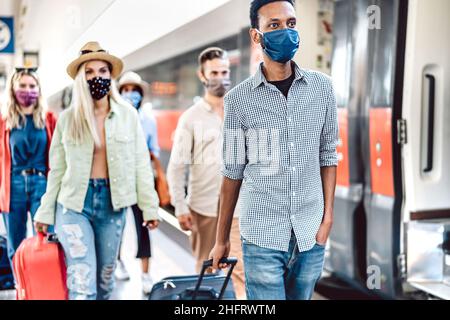 Foule de personnes marchant à la station de chemin de fer plate-forme couverte par masque de protection - négatif Voyage concept avec les jeunes étudiants sur la variante omicron Banque D'Images