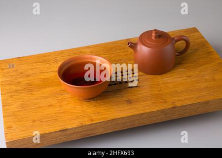 Théière et tasse avec thé pu-erh fraîchement préparé.Un set sur une table en bois pour les cérémonies du thé. Banque D'Images