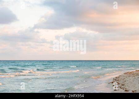 Lever de soleil doux sur la côte de l'océan Atlantique.Paysage de mer aux vagues turquoise de la mer et aux teintes roses sur une plage touristique.Détente ho Banque D'Images