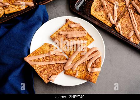 Pain plat grillé recouvert de poudre de cacao et de yaourt au fromage : yaourt au beurre de chocolat et d'arachide arrosé de croustilles de pain plat saupoudrées de coco Banque D'Images