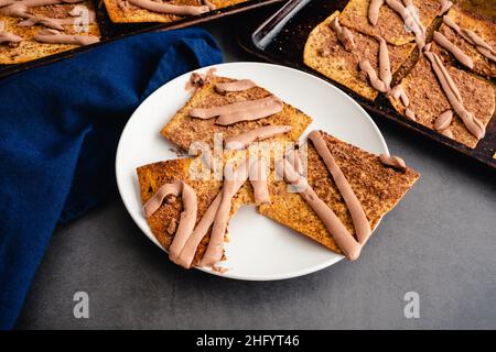 Pain plat grillé recouvert de poudre de cacao et de yaourt au fromage : yaourt au beurre de chocolat et d'arachide arrosé de croustilles de pain plat saupoudrées de coco Banque D'Images