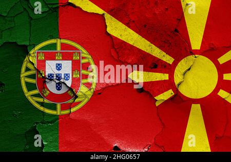 Drapeaux du Portugal et de la Macédoine du Nord peints sur un mur fissuré Banque D'Images