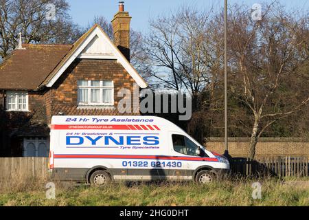 Une fourgonnette blanche fournissant 24 heures de tire assistance DYNES en route vers le client avec une maison dans l'arrière-plan Londres Angleterre Royaume-Uni Banque D'Images