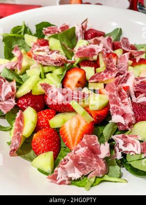 La salade d'épinards à la fraise et au bacon avec une vinaigrette simple est faite en combinant l'huile d'olive, le vinaigre balsamique et un peu de sucre brun. Banque D'Images