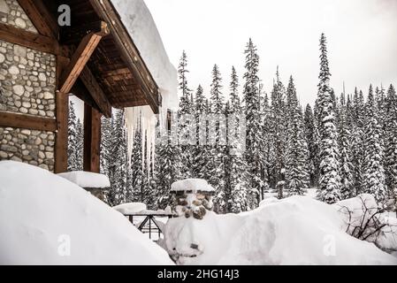 Parc national Yoho, Canada - décembre 23 2021 : cabane en bois et cabane à flanc de lac Emeraude gelé se cachant dans une forêt d'hiver surmontée par le mont rockies Banque D'Images
