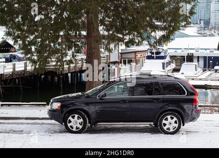 Une voiture noire garée à l'extérieur dans une rue par une journée d'hiver enneigée au Canada.Vue sur la rue, photo de voyage, mise au point sélective. Banque D'Images