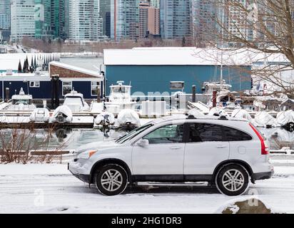 Une voiture blanche garée à l'extérieur dans une rue lors d'une journée d'hiver enneigée au Canada.Vue sur la rue, photo de voyage, mise au point sélective. Banque D'Images