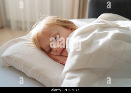 fille dormant dans la chambre un matin ensoleillé Banque D'Images