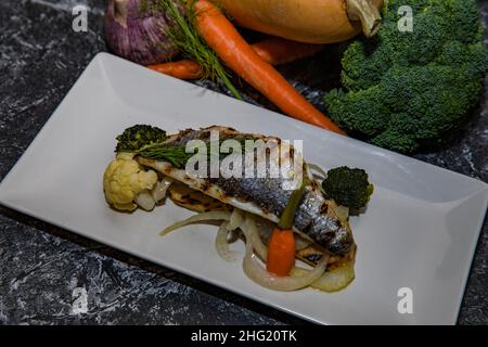 Assiette de bream de mer avec oignon, brocoli, carotte Banque D'Images