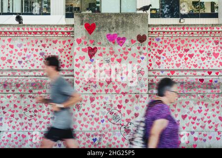 Une section du mur commémoratif national Covid couverte de coeurs roses peints et d'hommages aux victimes de la pandémie sur la rive sud de Londres Banque D'Images