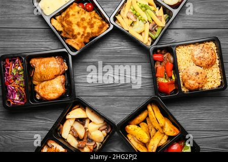Délicieux repas dans des boîtes à lunch sur fond de bois gris Banque D'Images