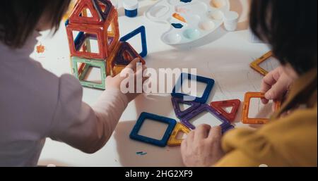 Enfant avec sa mère recueille un constructeur magnétique, gros plan, vue arrière Banque D'Images