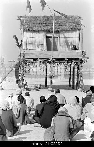 Indian Siddha Yogi saint Devraha Baba, se trouve sur son machan, une plate-forme de bois et de chaume, alors qu'il reçoit des dévotés sur les rives de la rivière Yamuna le 2 février 1989 près de Vrindavan, en Inde. Banque D'Images