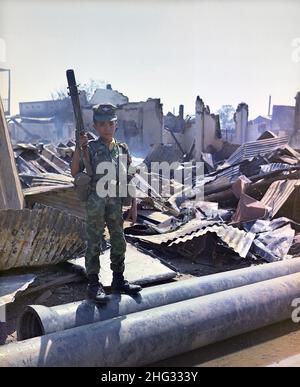 Un enfant soldat vietnamien en 1968.Ce soldat aéroporté ARVN de douze ans, équipé d'un lanceur de grenade M-79, a accompagné l'unité de la Force opérationnelle aéroportée dans un balayage à travers la zone dévastée entourant le cimetière national français sur Plantation Road après une longue bataille.Le jeune soldat a été « adopté » par la Division aéroportée. Banque D'Images