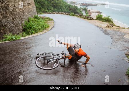 Un cycliste épuisé est tombé sur la route Banque D'Images