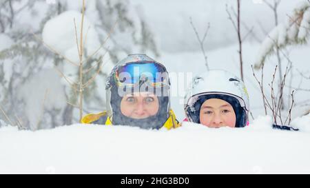 Les jeunes femmes d'origine caucasienne et sa fille passent du temps ensemble dans un parc de surf des neiges.Maman et fille dans un casque et des lunettes Banque D'Images