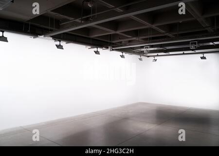 vue de face de l'intérieur de style industriel de l'exposition avec des lumières et des murs blancs vides Banque D'Images