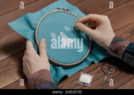 Femme faisant le point sur la toile et le motif de broderie. Banque D'Images