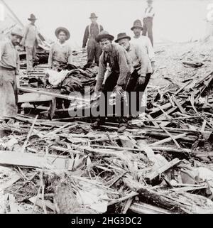 Photo d'archives de l'ouragan Galveston 1900.Personnes transportant des corps sur civière parmi les bâtiments détruits par l'ouragan et l'inondation.Galveston, T. Banque D'Images