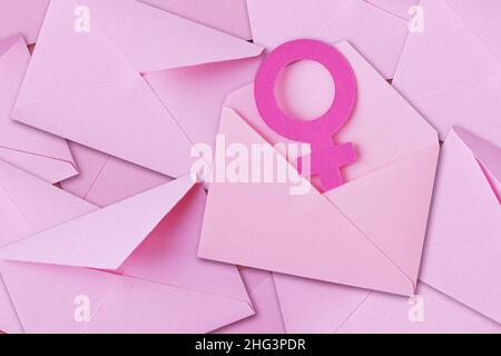 Pile d'enveloppes roses avec symbole de sexe féminin - concept de l'envoi et de la femme Banque D'Images