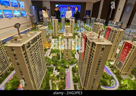 QINGZHOU, CHINE - 21 DÉCEMBRE 2021 - les acheteurs de maisons regardent les tables de sable dans un bureau de vente immobilier à Qingzhou, dans la province de Shandong en Chine orientale, Banque D'Images