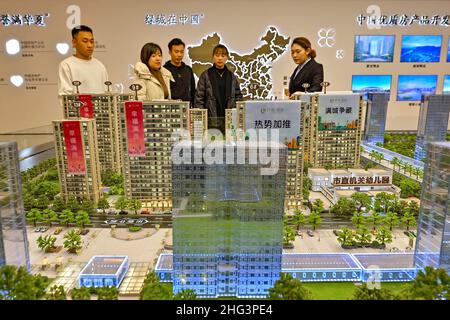QINGZHOU, CHINE - 21 DÉCEMBRE 2021 - les acheteurs de maisons regardent les tables de sable dans un bureau de vente immobilier à Qingzhou, dans la province de Shandong en Chine orientale, Banque D'Images