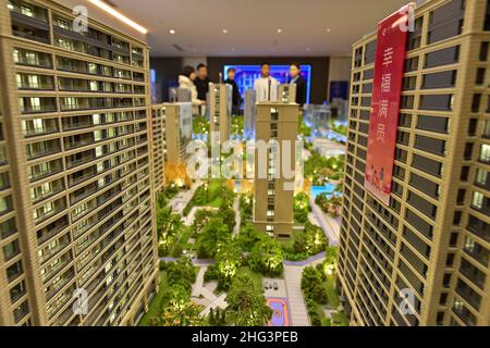 QINGZHOU, CHINE - 21 DÉCEMBRE 2021 - les acheteurs de maisons regardent les tables de sable dans un bureau de vente immobilier à Qingzhou, dans la province de Shandong en Chine orientale, Banque D'Images