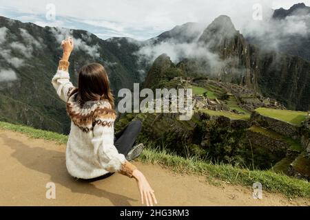 Une jeune femme regardant le Machu Picchu depuis le sommet de la colline Banque D'Images