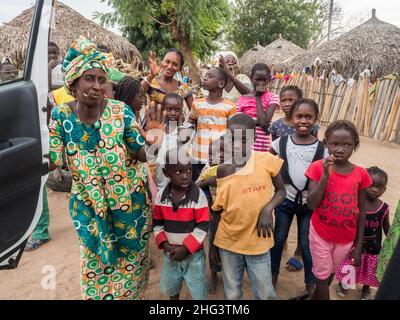 Sénégal, Afrique - janvier 2019 : famille africaine dans un petit village africain traditionnel avec des maisons en argile recouvertes de feuilles de palmier Banque D'Images