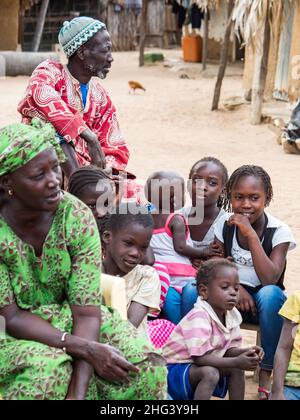 Sénégal, Afrique - janvier 2019 : famille africaine dans un petit village africain traditionnel avec des maisons en argile recouvertes de feuilles de palmier Banque D'Images