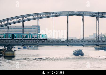 Métro Paris ligne 5 traversant la structure métallique du viaduc d'Austerlitz au-dessus de la Seine, une matinée nuageux dans la capitale française Banque D'Images