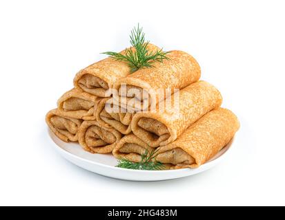 Une pile de crêpes farcies décorées d'aneth frais isolé sur un fond blanc.Crêpes russes traditionnelles farcies à la viande.Crêpes Banque D'Images