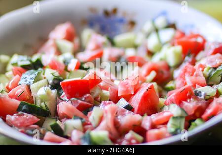 Salade de légumes frais de tomates et concombres à la crème sure et à la verdure. Banque D'Images