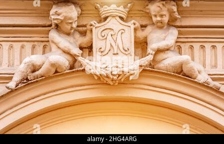 Deux anges anciens sous la forme d'enfants sur l'architecture du bâtiment. Banque D'Images