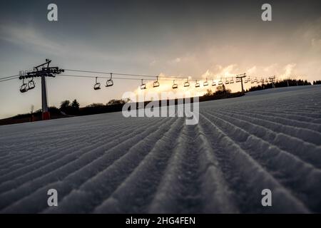 Nouvelle piste de ski soignée ou piste fraîche.Videz les remontées mécaniques en arrière-plan. Banque D'Images