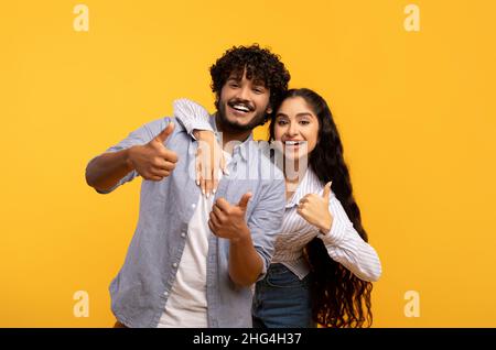 Le meilleur choix.Portrait d'un couple indien excité montrant un geste de pouce vers le haut, approuvant ou recommandant quelque chose de bon Banque D'Images