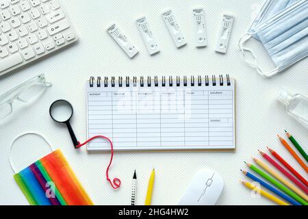 Étude scolaire ou universitaire avec des tests rapides de covid et des masques médicaux.Éducation pendant les pandémies de coronavirus.Calendrier hebdomadaire vide pour planifier les rendez-vous Banque D'Images
