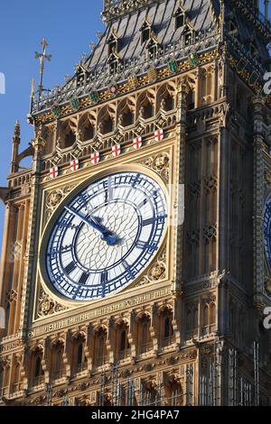 La face de l'horloge de la Tour Elizabeth (Big Ben) avec des mains et des chiffres bleus brille après la restauration dans la lumière du soleil, Londres, Royaume-Uni Banque D'Images