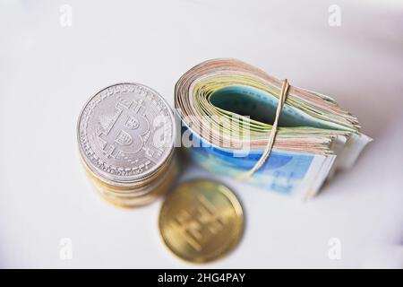 Rouler les billets israéliens Shekel ils près des jetons crypto-monnaies Ethereum eth, vu d'en haut, sur fond blanc.Mise au point sélective. Avec espace pour le placement du texte.Isolé .Photo de haute qualité Banque D'Images