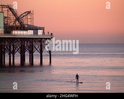 Paddleboard au crépuscule, près de la jetée de Brighton Palace, en Angleterre Banque D'Images