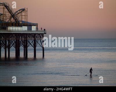 Paddleboard au crépuscule, près de la jetée de Brighton Palace, en Angleterre Banque D'Images