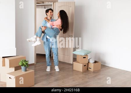 Heureux couple millénaire célébrant la journée de déménagement dans un nouvel appartement Banque D'Images