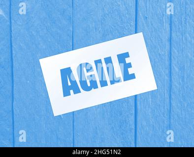 Carte de visite papier avec texte AGILE , gros plan sur fond en bois. Concept d'entreprise Banque D'Images