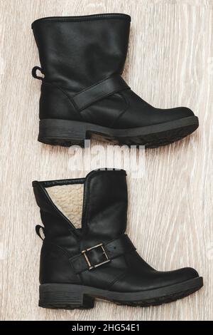 Deux bottes en cuir noir pour femmes sur fond gris.Chaussures et accessoires pour femmes. Banque D'Images